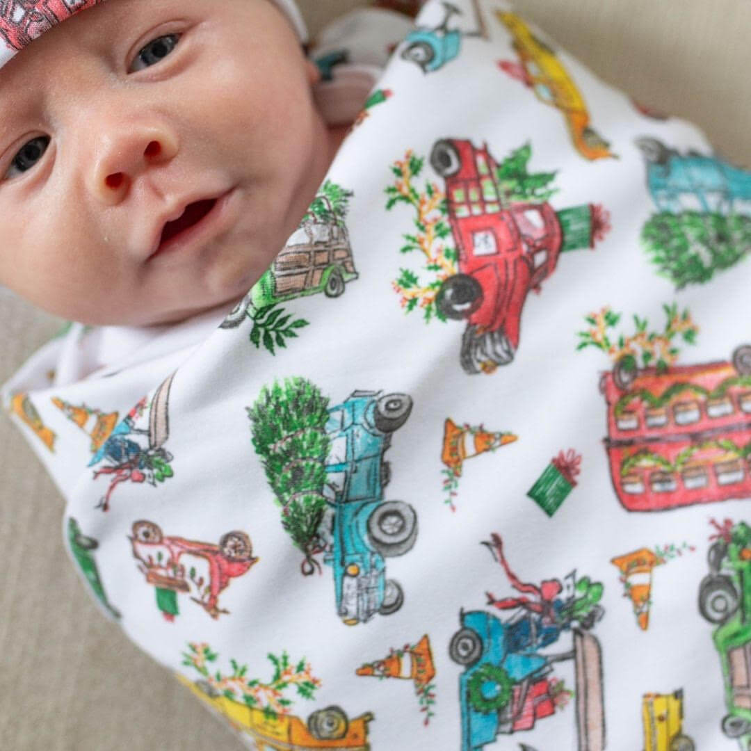 Newborn wrapped in christmas blanket.