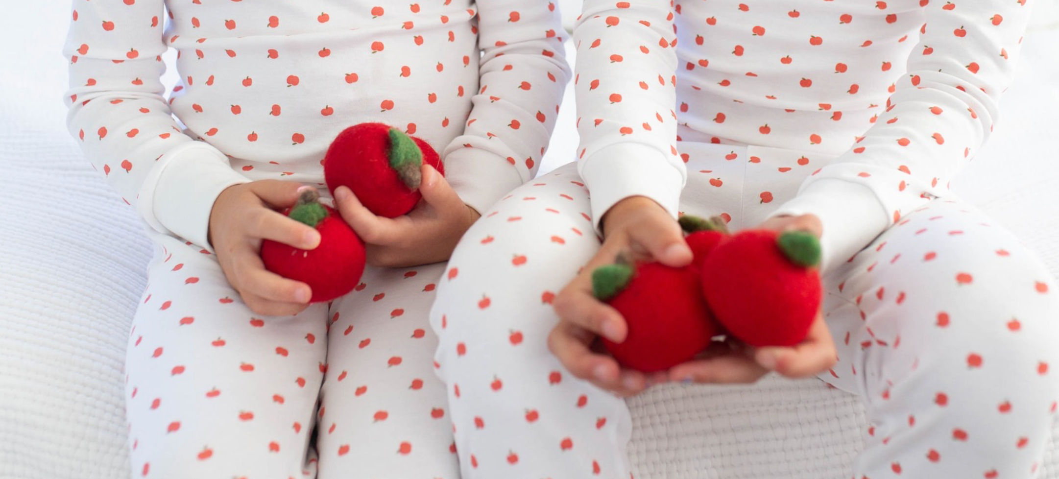 two kids in pjs with apples