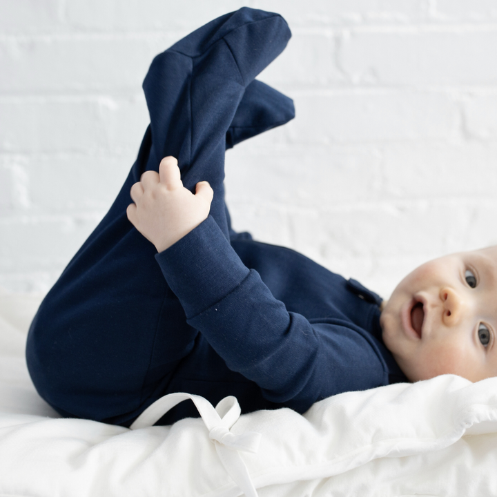 a baby wearing Zipper Romper in Navy