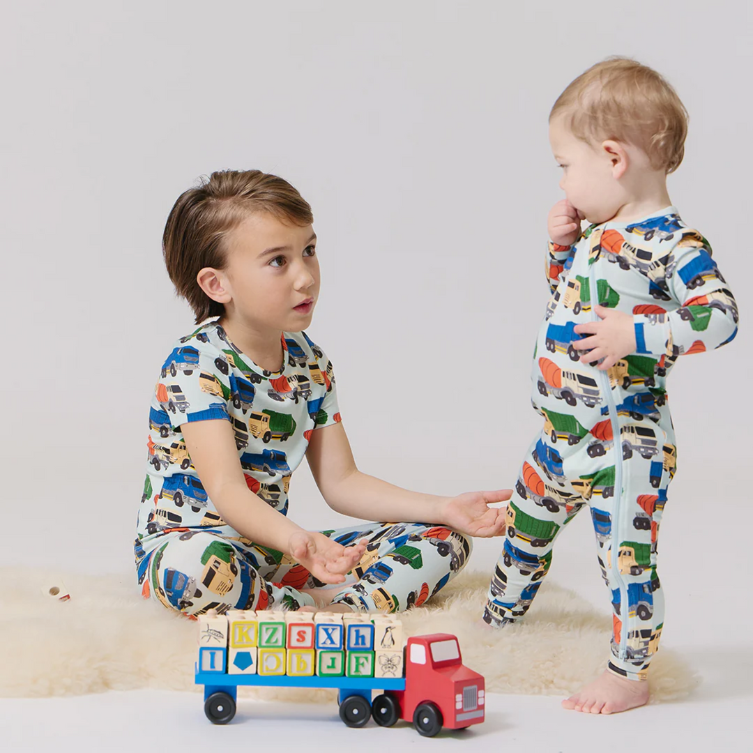 a baby boy wearing Baby Bamboo Romper - Dump Trucks