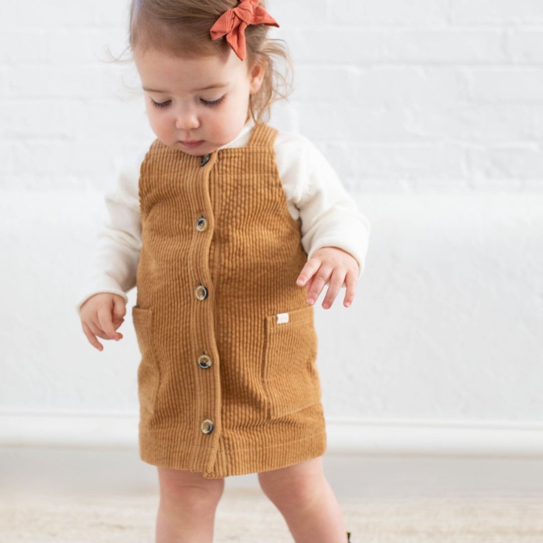 baby girl wearing brown corduroy jumper