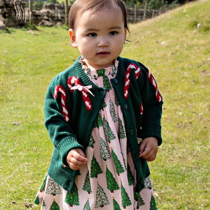 a baby wearing Baby Constance Sweater - Green Candy Cane Bows