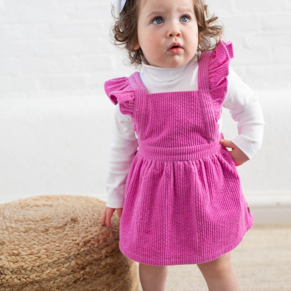 baby girl wearing pink poppy cord jumper