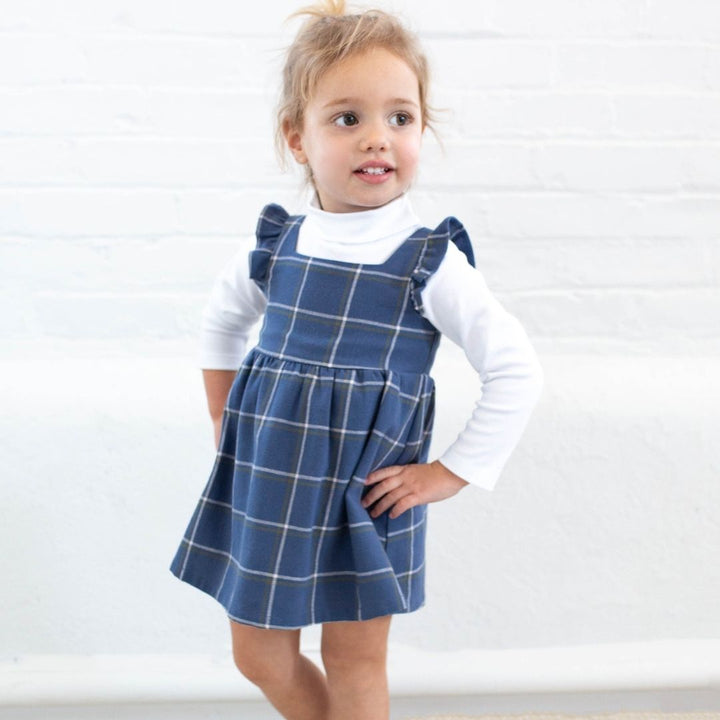 little girl wearing navy plaid jumper