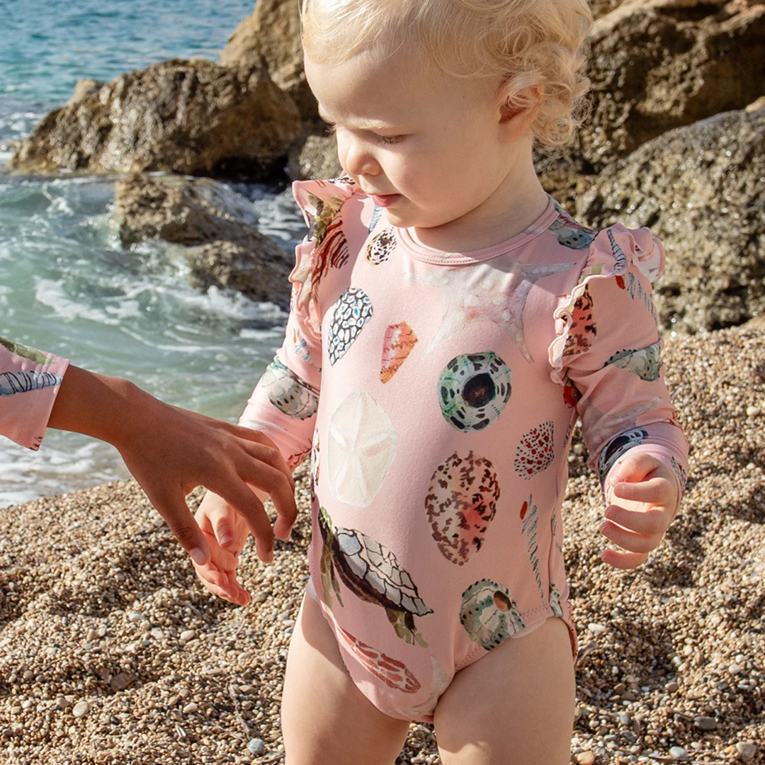 a baby girl wearing Baby Rachel Suit - Pink Watercolor Shells