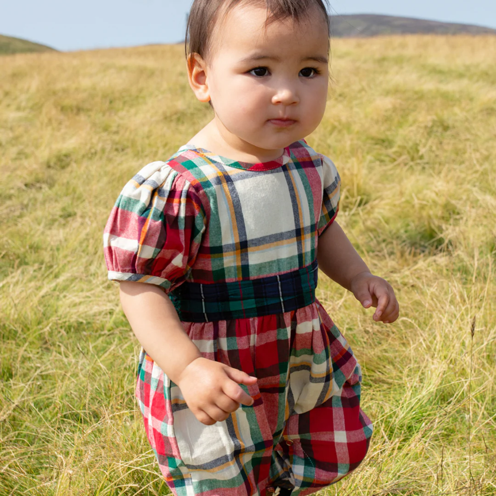 a baby wearing Baby Ruby Jumper - Holiday Tartan