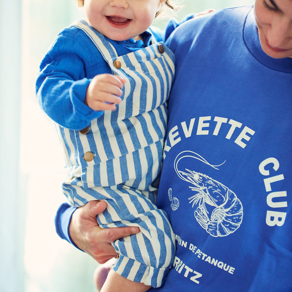 a baby wearing Baby Overalls in Cobalt Stripe