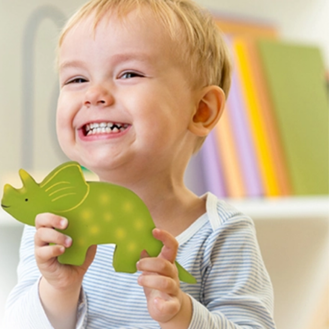 a baby boy holding Baby Triceratops Natural Organic Rubber Toy