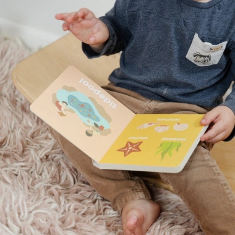 a little boy holding a Beach Baby Book