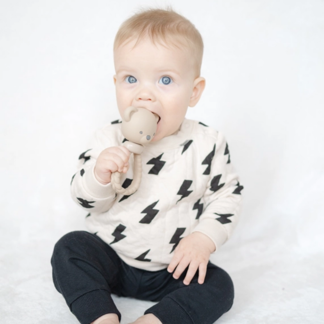 a baby playing Bear Sweetie Rattle