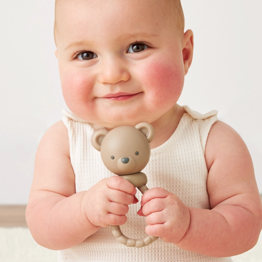 a baby playing Bear Sweetie Rattle