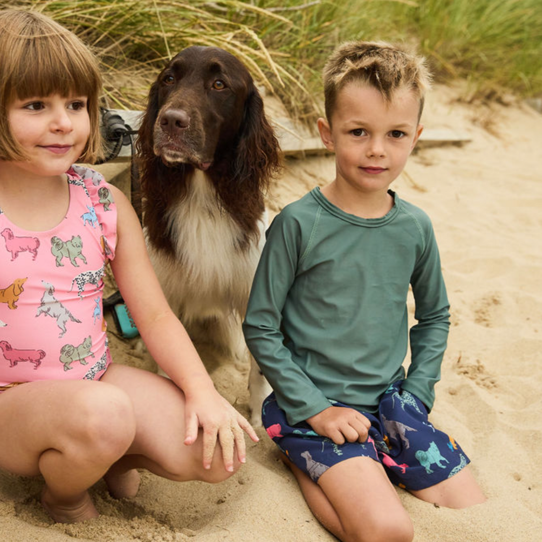 Swim Trunk - Navy Dogs 2 child and 1 dog sitting at the sand