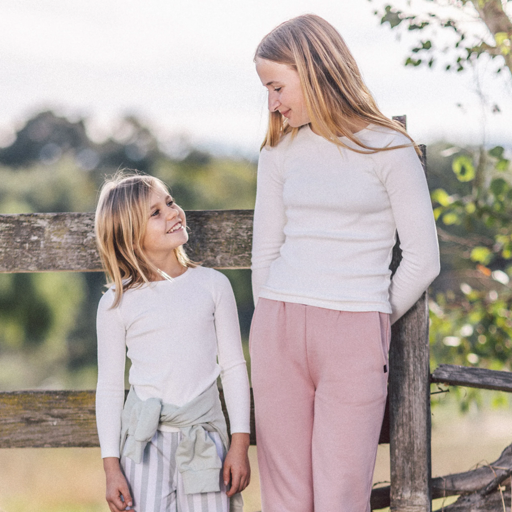 a girls wearing Brooklin Long Sleeve Ribbed Top in Cream