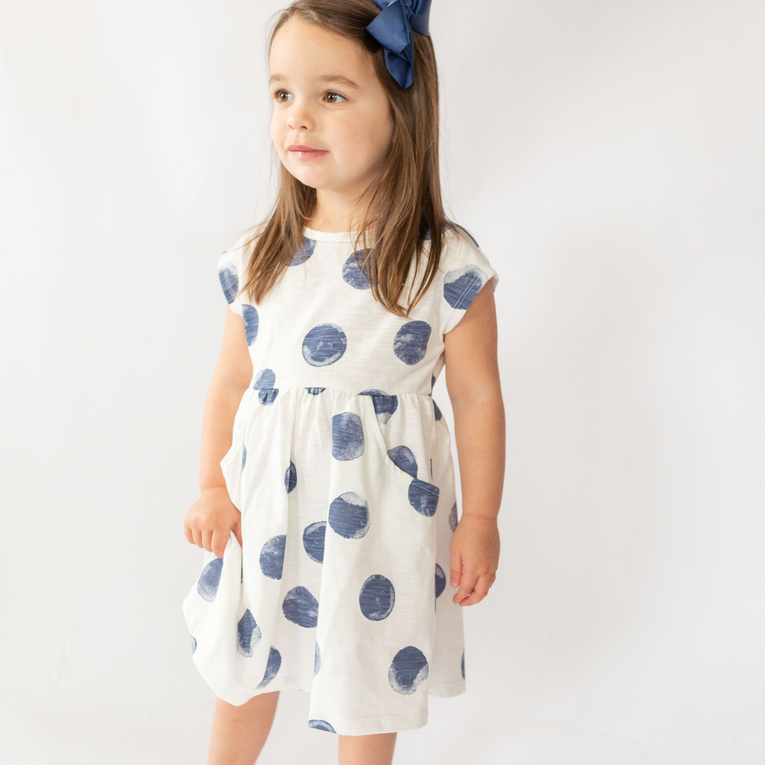 a little girl wearing Carly Dress in Washed Indigo Dot