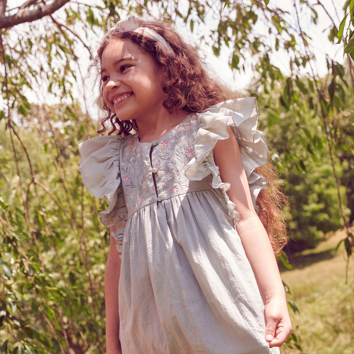 a little girl wearing Clothilde Dress in Swiss Dobby Sage