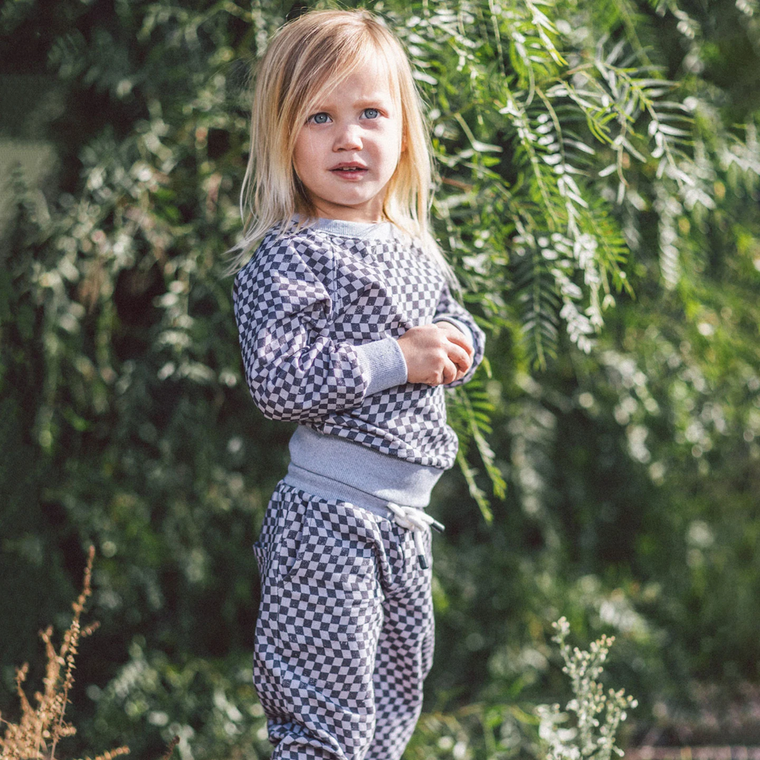 a little girl wearing Coast to Coast Baby Pullover in Gray Skies