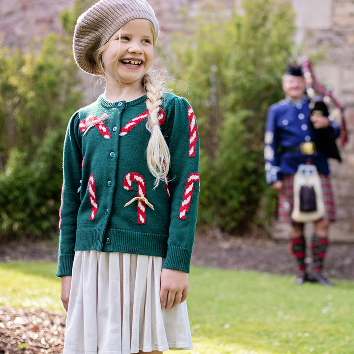 a girl wearing Constance Sweater - Green Candy Cane Bows