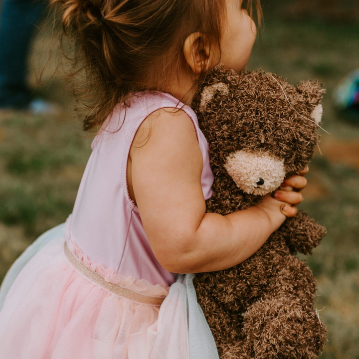 a girl hugging Cubby Bear