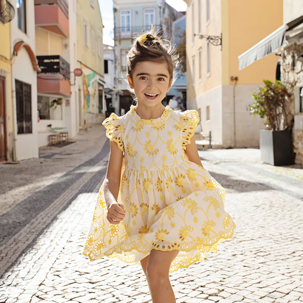 a girl wearing Cynthia Dress - Bright Yellow Eyelet