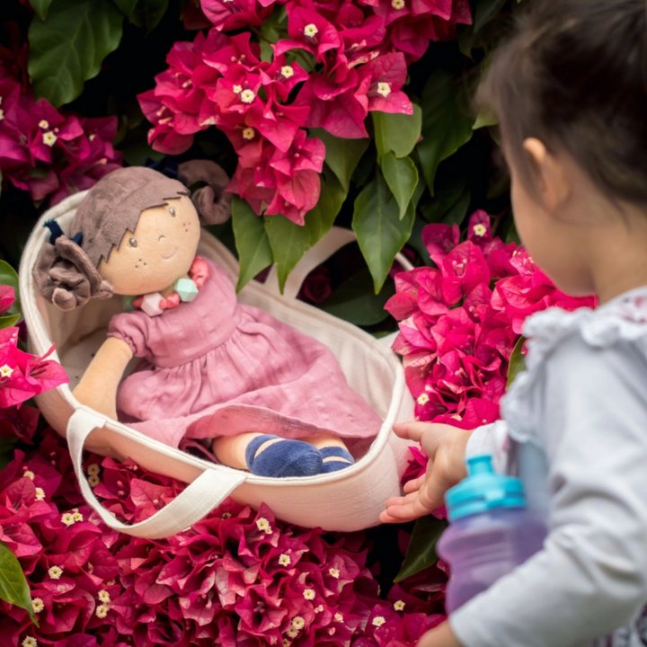 a girl playing Doll Carry Cot 