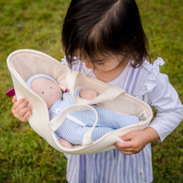 a girl holding Doll Carry Cot 