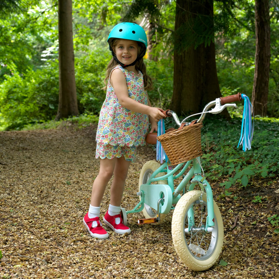 a little girl riding a bicycle wearing Floral Scalloped Top and Shorts Set