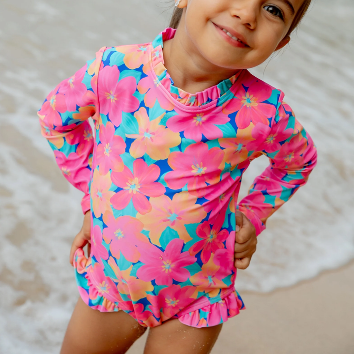 a girl wearing Frill Chaser Baby Surf Suit in Pink Carnation