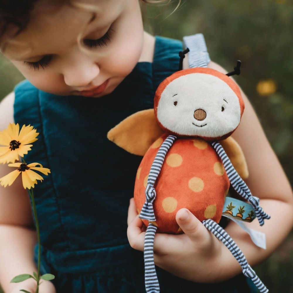 a little girl holding the Girlbug Rattle