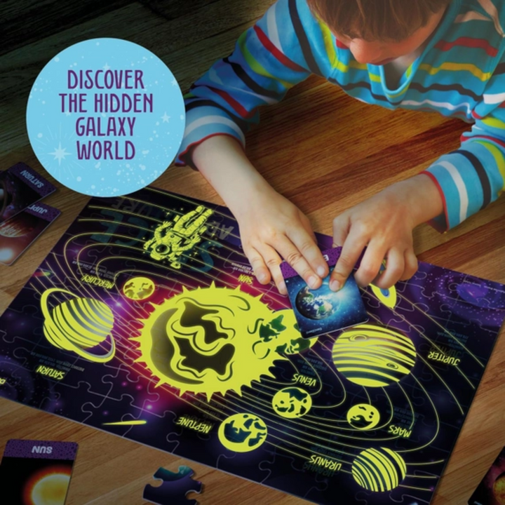 a kid playing Glow in The Dark 100 Piece Galaxy Jigsaw Puzzle