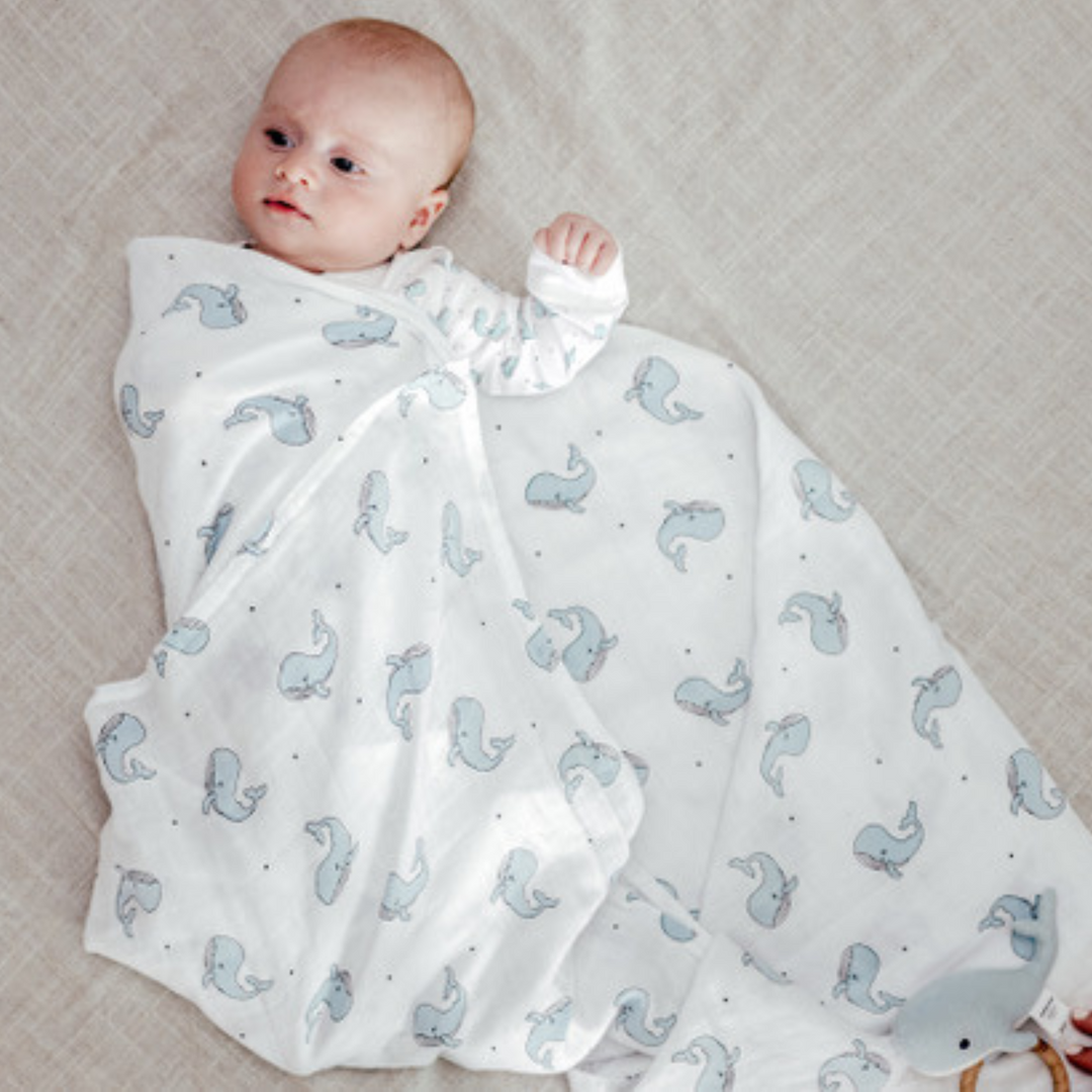 a baby with Happy Whale Blanket in Blue