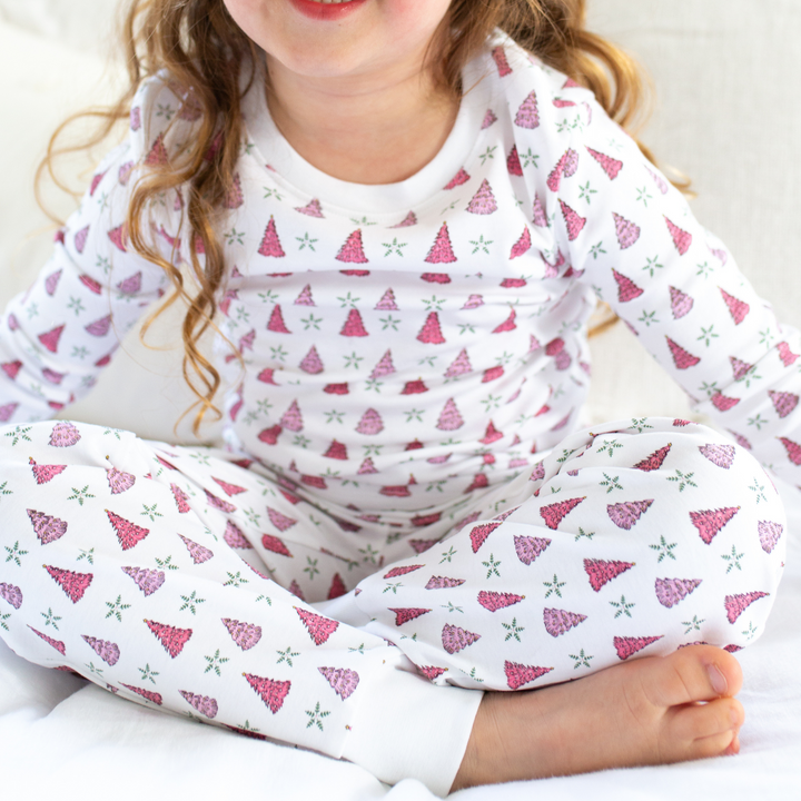 a little girl wearing Holiday Tree Pajama Set in Pink Frost