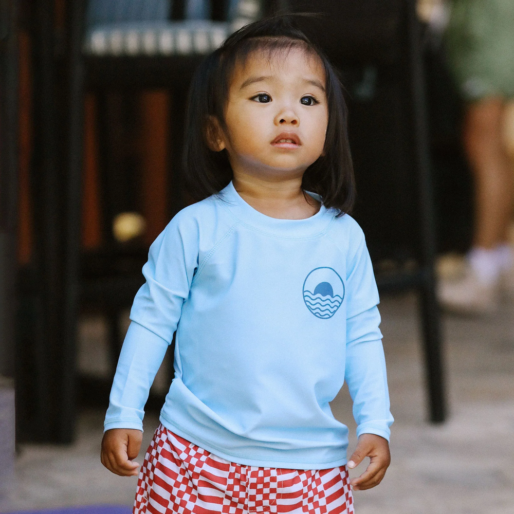 a baby wearing Icon Baby Long Sleeve Rashguard in Crystal Blue