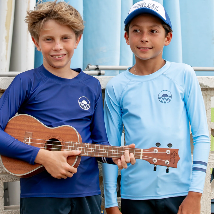 a boy wearing Icon Long Sleeve Rashguard in Crystal Blue