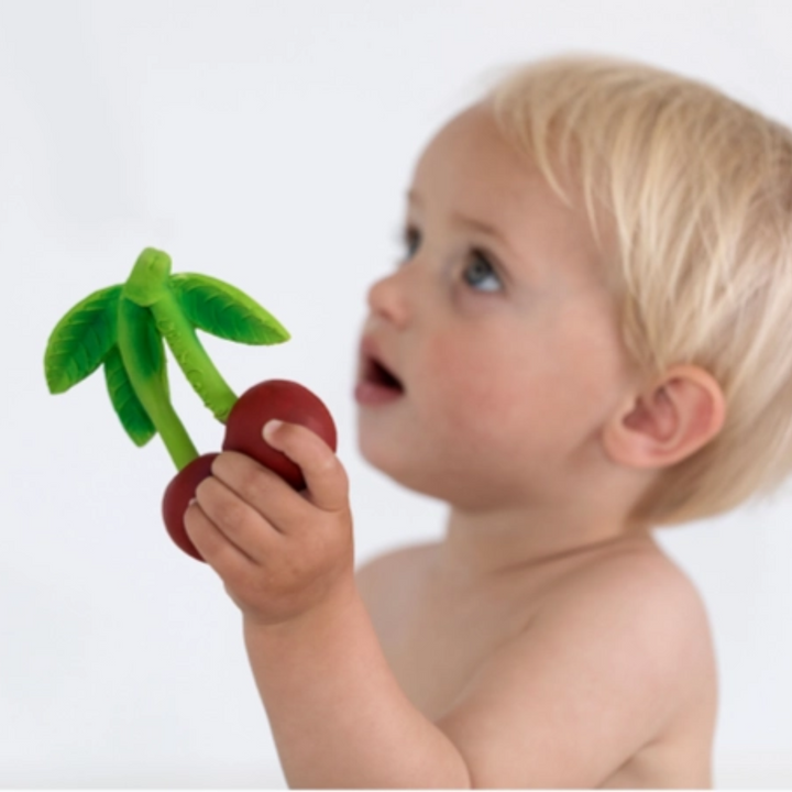 a baby holding Mery the Cherry