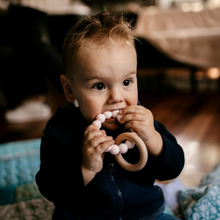 a baby using Moon Teether - Blush