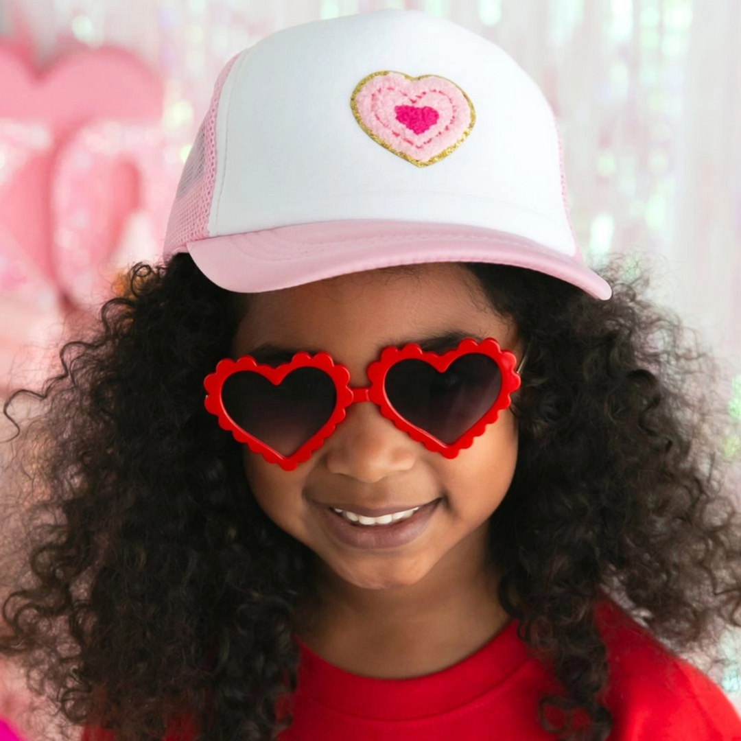 a girl wearing Multi Heart Patch Trucker Hat in Pink