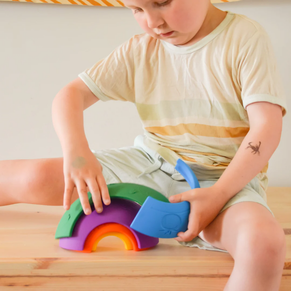 a boy playing Over the Rainbow Stacking Arches - Bright