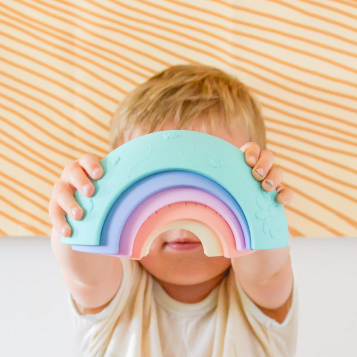 a kid playing Over the Rainbow Stacking Arches - Pastel