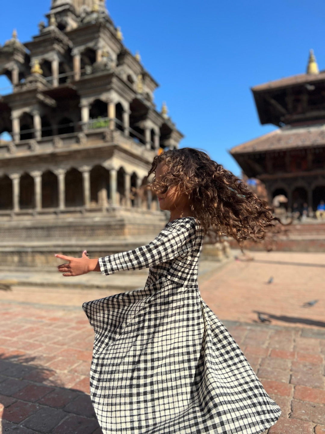 girl spinning in plaid dress