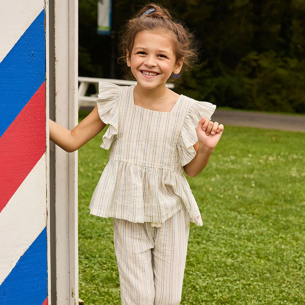 a girl standing at the park wearing Elsie Top - Riviera Stripe