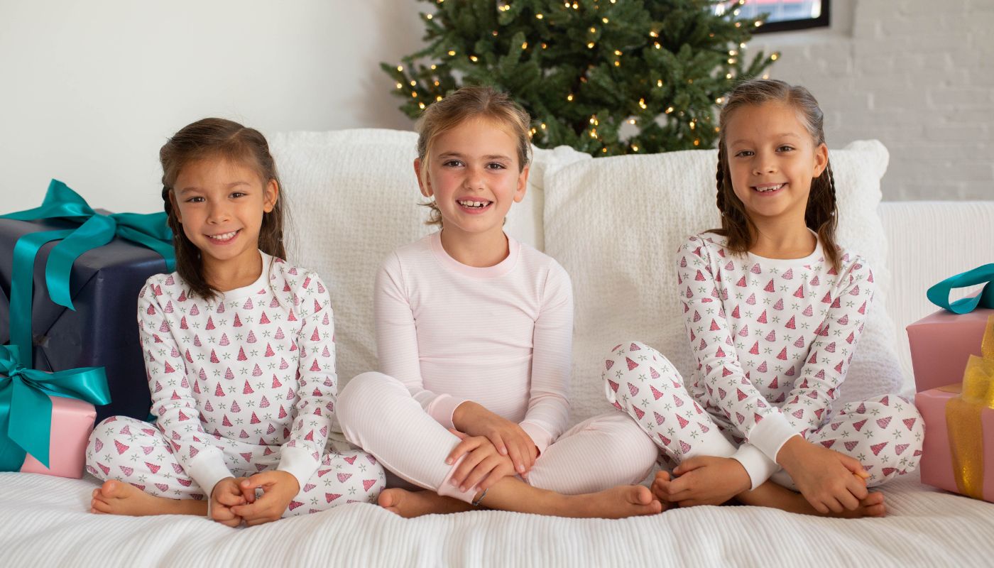 3 girls sitting on a bed in pjs