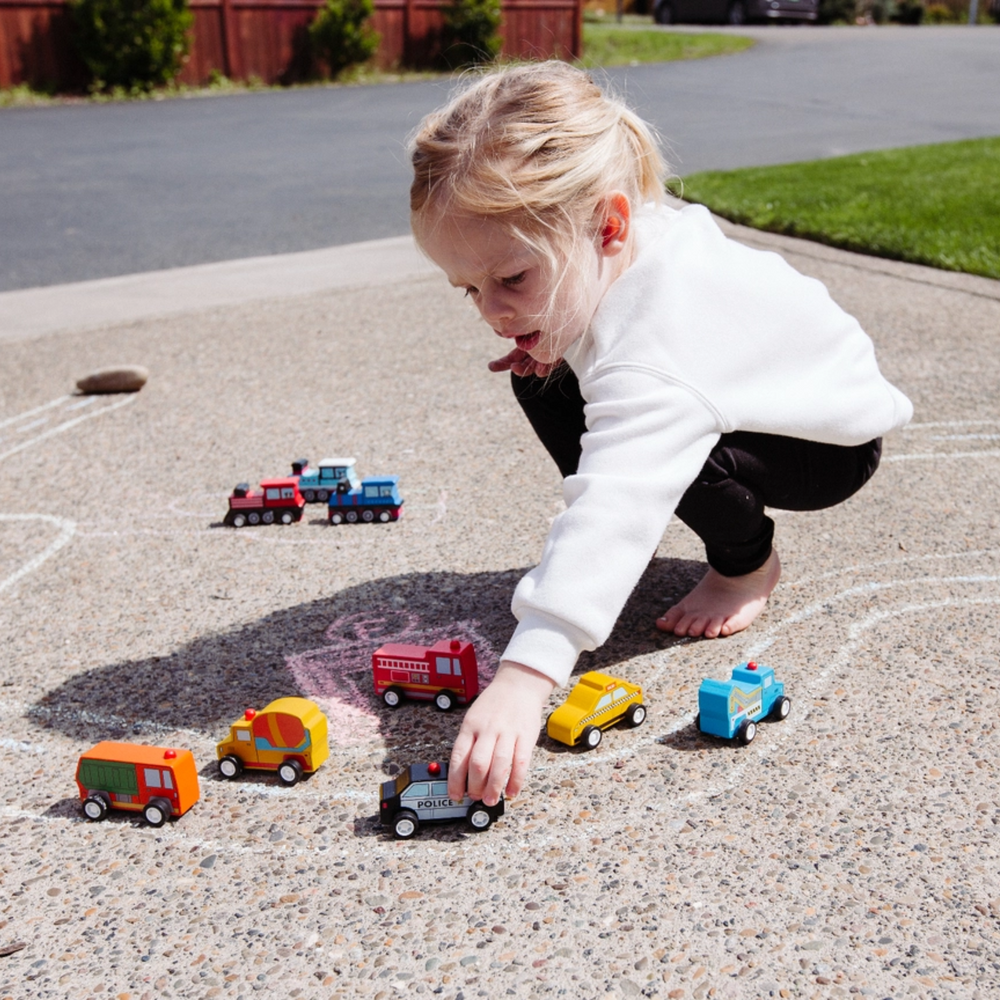 a girl playing Around the Town Wood Car - Firetruck