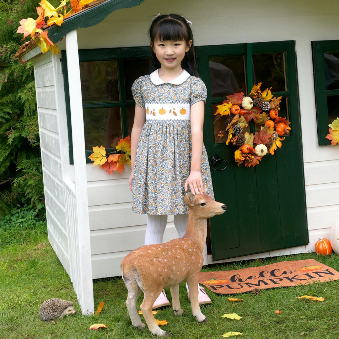 a girl wearing Pumpkin Smocked Dress