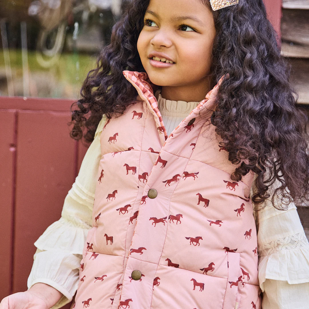 a girl wearing Reversible River Vest - Tiny Horses