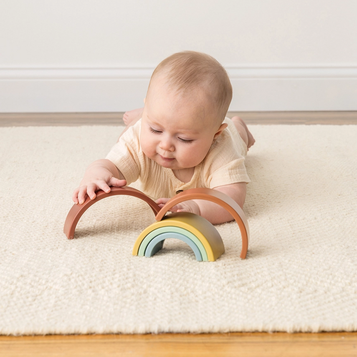 a baby playing Ritzy Rainbow Stacking Toy