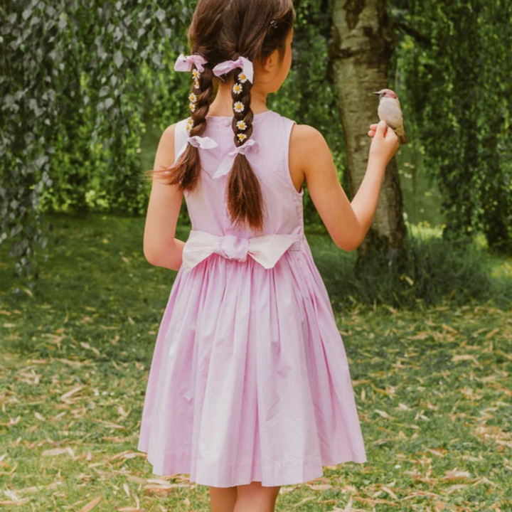Rose Pink Stripe Sleeveless Handsmocked Dress a girl holding a bird