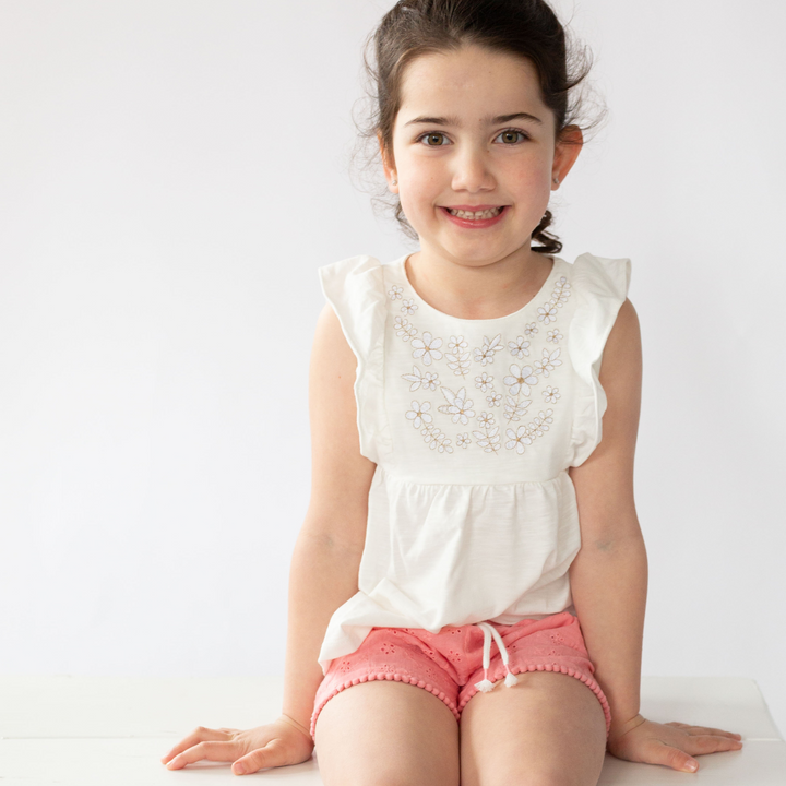 a little girl wearing Ruby Ruffle Embroidered Tank in Angel White