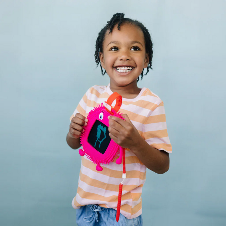 a girl playing Sketch Pals Doodle Board: Pink Fidgety Friends