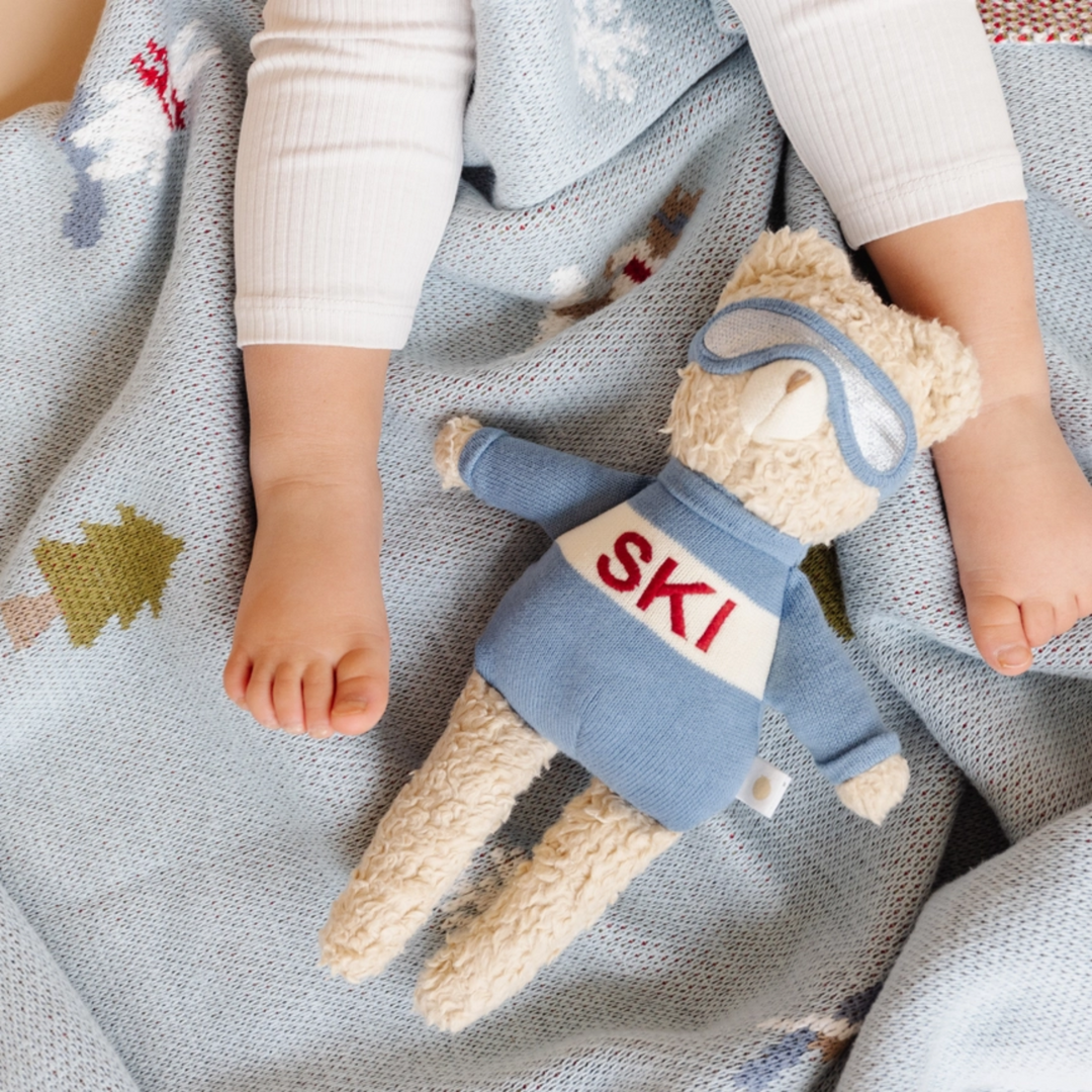 a baby lying on Ski Blanket in Blue