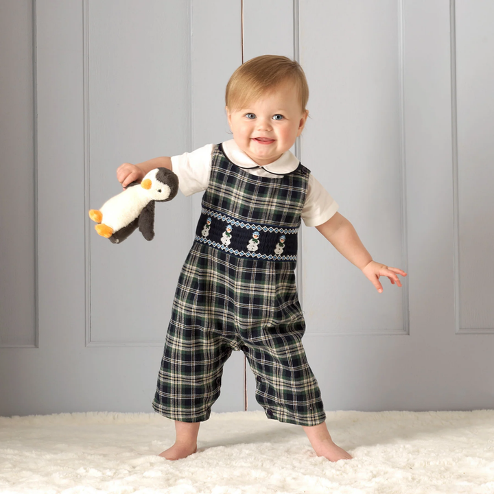 a baby wearing Snowman Smocked Dungarees in Navy